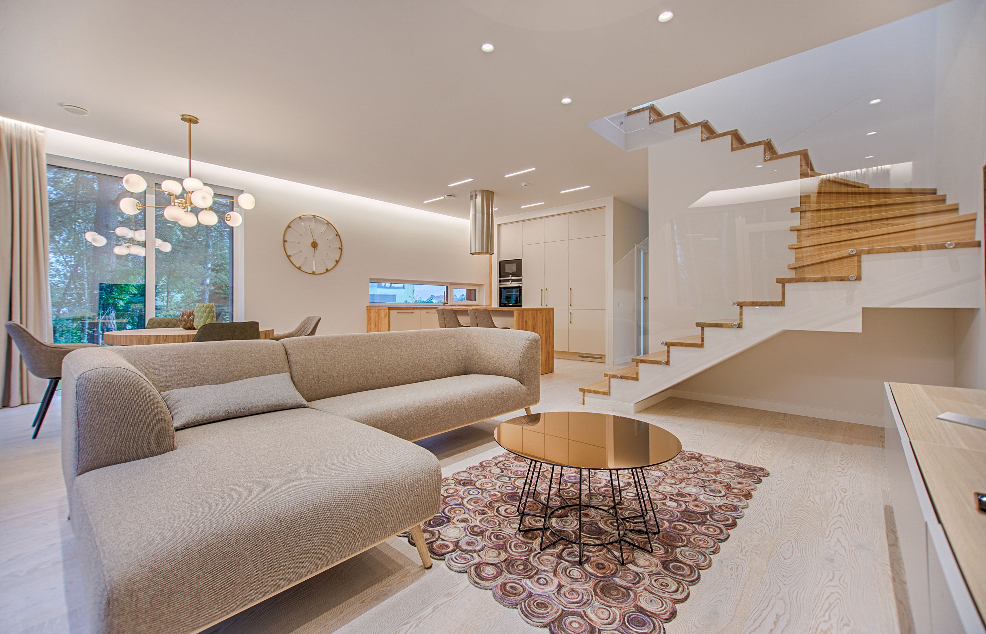 Bright open-plan living room with staircase and warm natural light